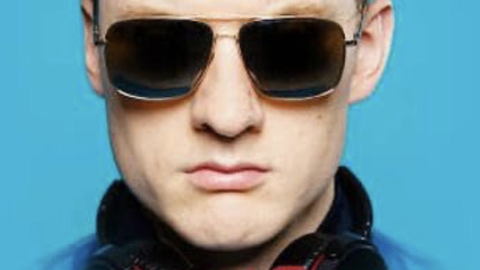 James Acaster in sunglasses and headphones against a blue background