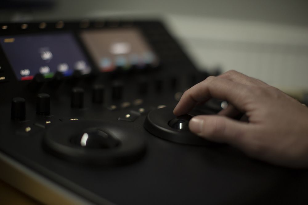 Hand on a colour grading panel trackball